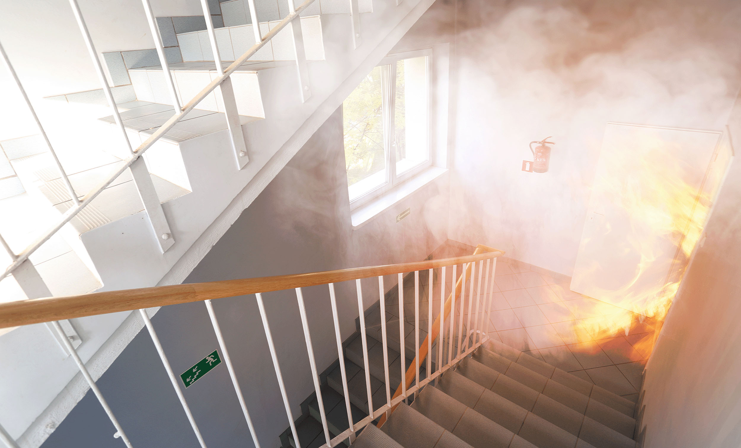 Staircase in a building filled with smoke and flames during a fire emergency, emphasizing the importance of buildings and fire insurance coverage.