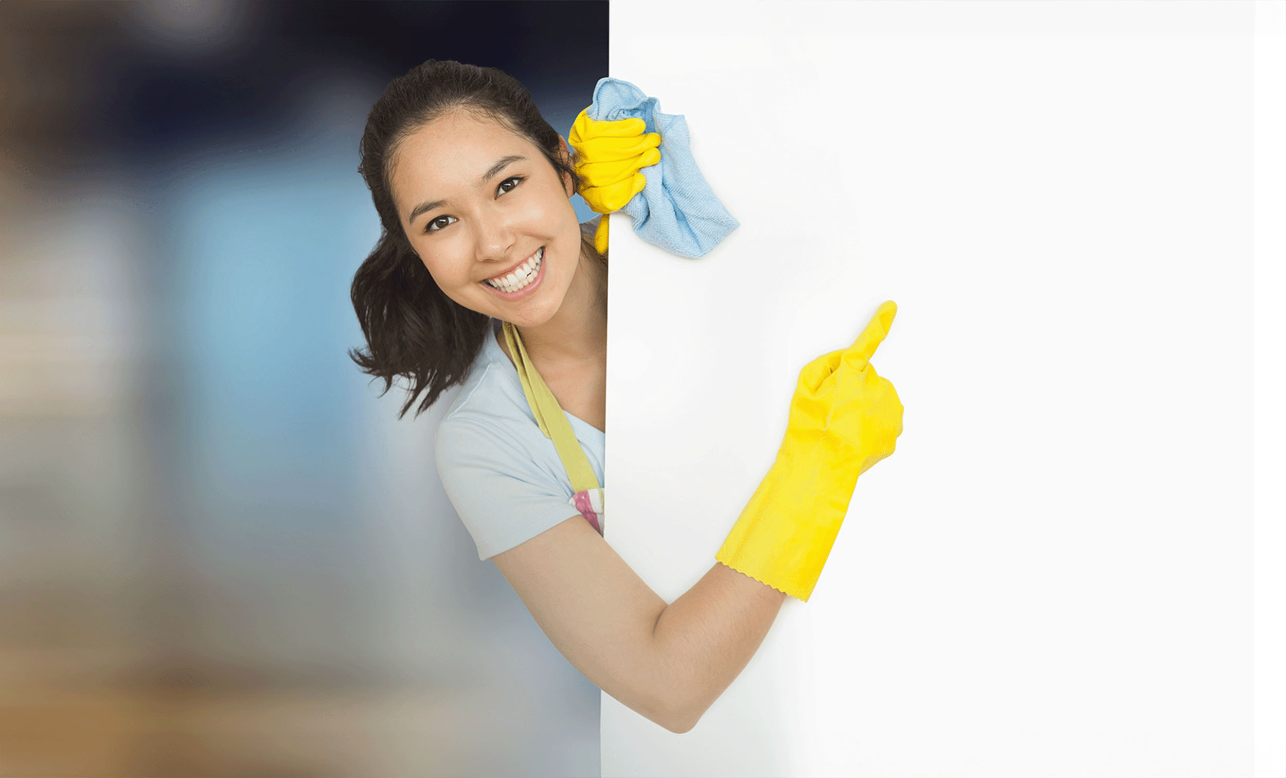 Smiling female cleaner wearing yellow gloves and holding a cleaning cloth, pointing to a blank white space, highlighting the need for domestic helper insurance coverage.
